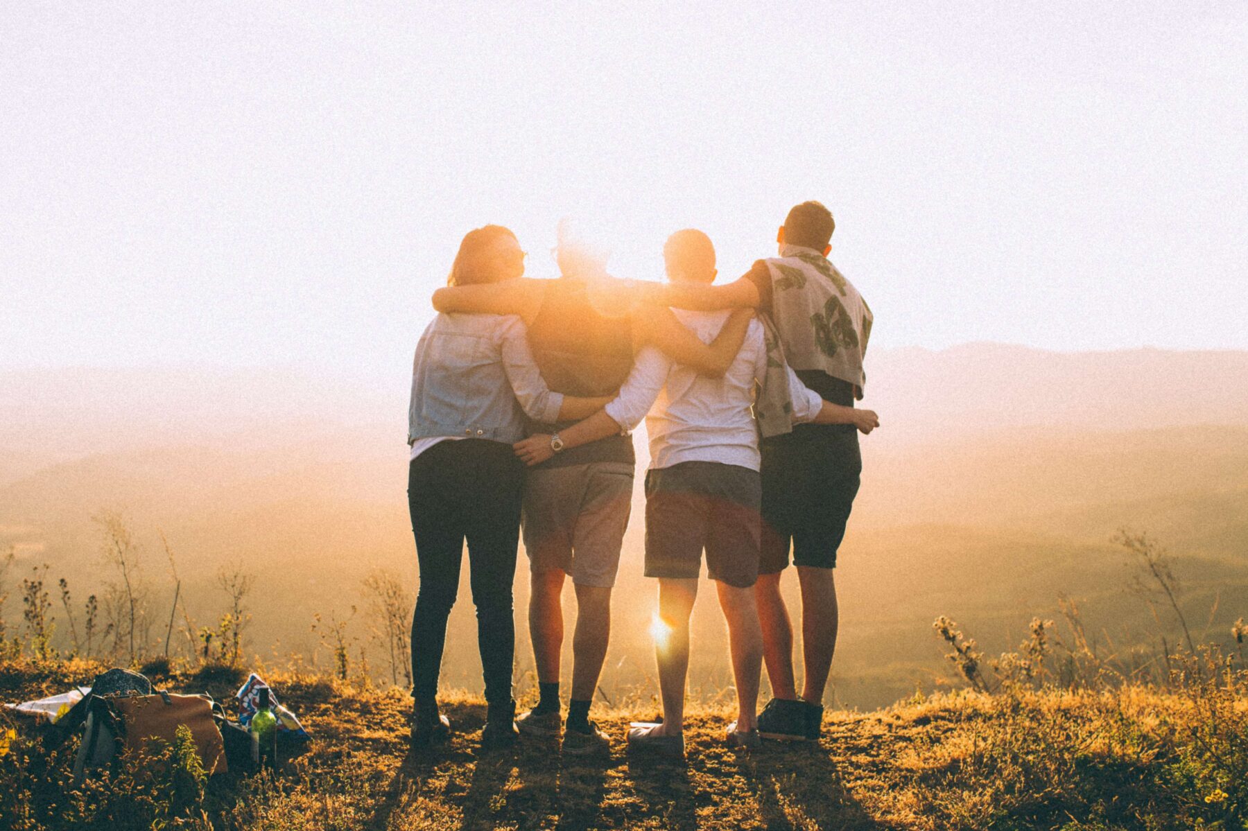 friends looking at a sunset from a mountain